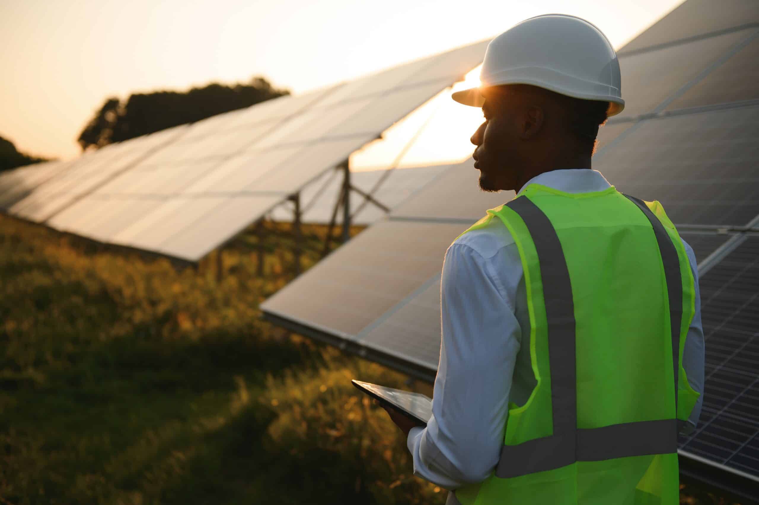 African american technician check the maintenance of the solar panels. Black man engineer at solar station.
